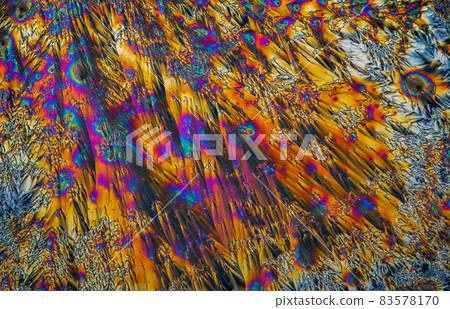 Extreme macro photograph of Vitamin C crystals forming abstract modern art patterns, when illuminated with polarized light, under a microscope objective with 10x magnification 83578170