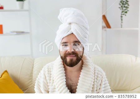 Young man with patches under the eyes at home. Concept of cosmetology for men. Spa at home, body and skin care Young man with patches under the eyes at home. Concept of cosmetology for men. Spa at home, body and skin care 83578952