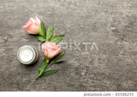 Composition with cosmetic products and beautiful roses on cement background. Copy space, flat lay Composition with cosmetic products and beautiful roses on cement background. Copy space, flat lay 83580255