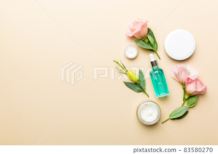 Composition with cosmetic products and beautiful roses on color background. Copy space, flat lay 83580270