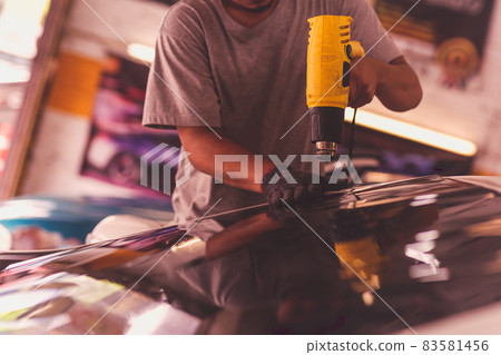Car specialist tinting film for car glass with hairdryer. Car specialist tinting film for car glass with hairdryer. 83581456