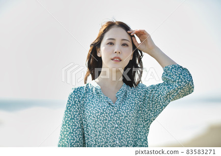 Young woman walking on a sandy beach Young woman walking on a sandy beach 83583271