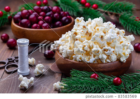 Ingredients for traditional handcrafted Christmas popcorn garland with red cranberries Ingredients for traditional handcrafted Christmas popcorn garland with red cranberries 83583569