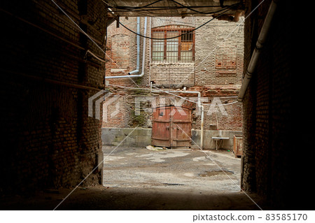 view of the courtyard of the old house through the entrance arch. Exterior of the old architecture 83585170