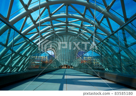 Modern stylish design made of glass and metal, pedestrian bridge over the Kura river in Tbilisi Modern stylish design made of glass and metal, pedestrian bridge over the Kura river in Tbilisi 83585180