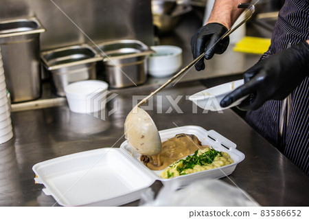 Chef preparing takeaway dish in the restaurant or pub , food delivery concept, home delivery, online order Chef preparing takeaway dish in the restaurant or pub , food delivery concept, home delivery, online order 83586652