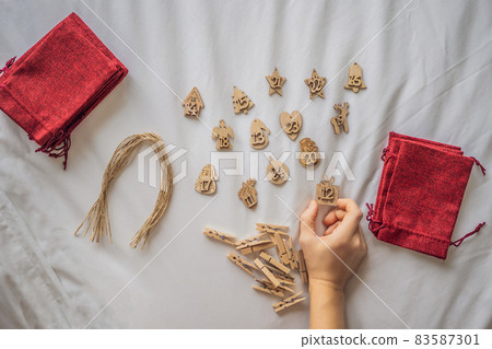 Woman making Christmas advent calendar. Pouches on a rope 83587301