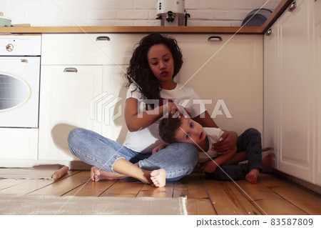 young pretty african american mother with little cute son on kitchen in morning preparing breakfast, lifestyle people concept young pretty african american mother with little cute son on kitchen in morning preparing breakfast, lifestyle people concept 83587809