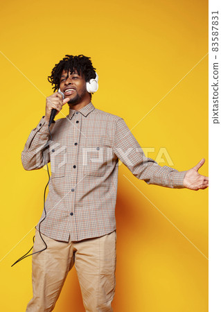 young handsome african american guy student posing cheerful and gesturing on yellow background, lifestyle people concept young handsome african american guy student posing cheerful and gesturing on yellow background, lifestyle people concept 83587831