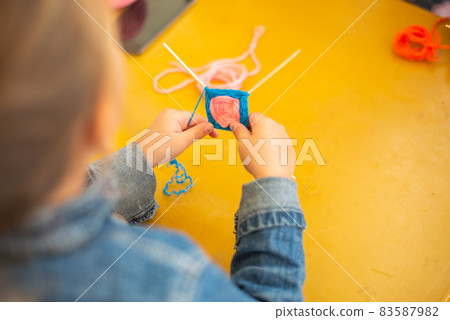 child makes a mandala of thread 83587982