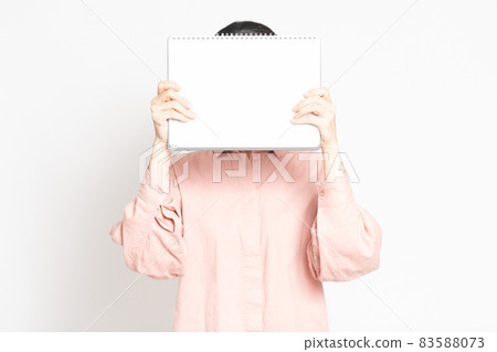 Woman holding a small sketchbook Woman holding a small sketchbook 83588073