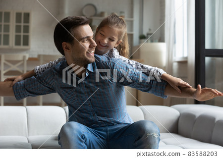 Joyful young father playing with small daughter. Joyful young father playing with small daughter. 83588203