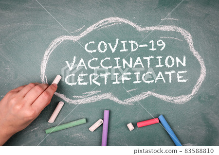 Covid-19 vaccination certificate. Pieces of chalk on a green chalkboard Covid-19 vaccination certificate. Pieces of chalk on a green chalkboard 83588810