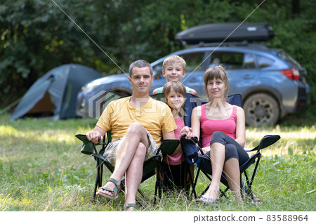 Happy family parents and kids resting together at campside. 83588964