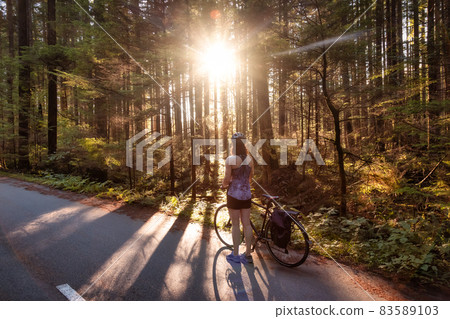 Adventurous Woman Bike Riding on a Trail in Forest Adventurous Woman Bike Riding on a Trail in Forest 83589103