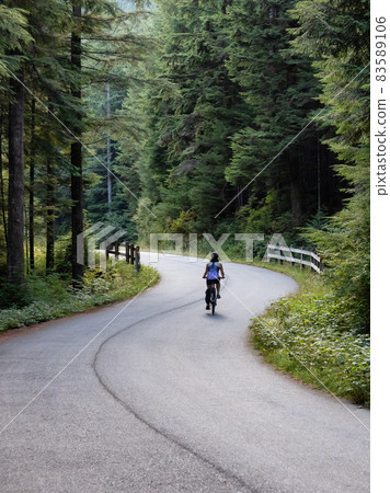 Adventurous Woman Bike Riding on a Trail in Forest 83589106
