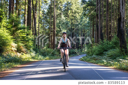 Adventurous Woman Bike Riding on a Trail in Forest 83589113