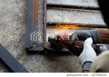 Close up, A man working with angle grinder. Iron gate repair Close up, A man working with angle grinder. Iron gate repair 83590030