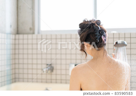 Young woman taking a shower in the bath 83590583