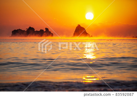 在松島和黑島之間蔓延的頭髮風暴,在日南海岸的鳥畑島和松島之間蔓延,被太平洋初升的太陽染成了黃昏。 在松島和黑島之間蔓延的頭髮風暴,在日南海岸的鳥畑島和松島之間蔓延,被太平洋初升的太陽染成了黃昏。 83592087