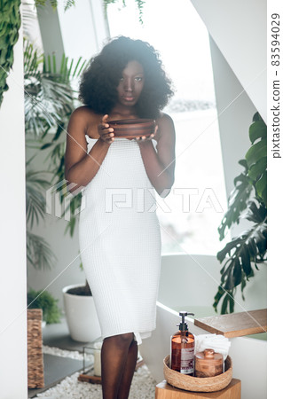 Cute young woman in a white bathrobe relaxing 83594029