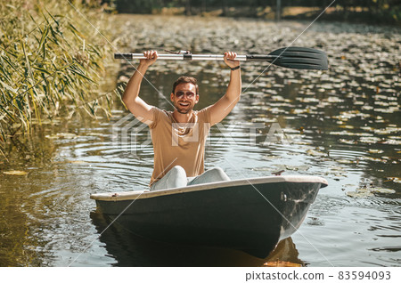 Joyful man with raised oar over his head Joyful man with raised oar over his head 83594093