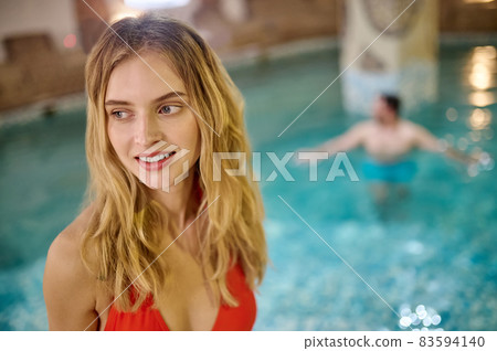 A pretty young woman and her boyfriend spending time in a pool in spa center A pretty young woman and her boyfriend spending time in a pool in spa center 83594140