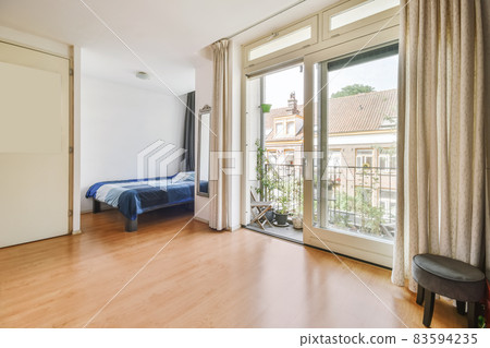 Bedroom with a single bed and a door leading to the balcony 83594235