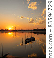 Small boat in the sunset 83594729