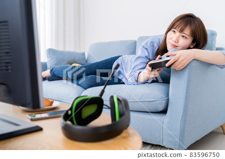 A woman playing an online game while lying on the sofa and relaxing 83596750