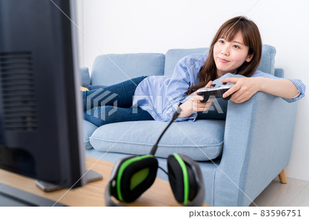 A woman playing an online game while lying on the sofa and relaxing 83596751