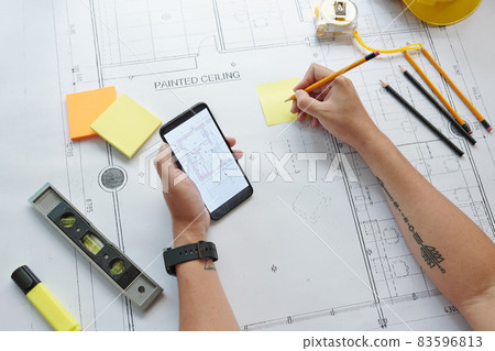 Engineer Checking Plan on Smartphone 83596813