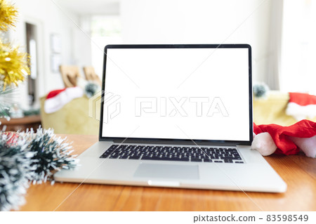 Laptop with copy space on screen lying on table with christmas decorations Laptop with copy space on screen lying on table with christmas decorations 83598549