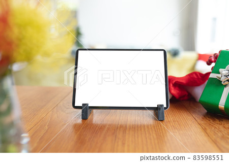 Tablet with copy space on screen lying on table with christmas decorations Tablet with copy space on screen lying on table with christmas decorations 83598551