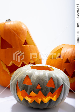 Composition of three halloween carved pumpkins with copy space on white background 83598661