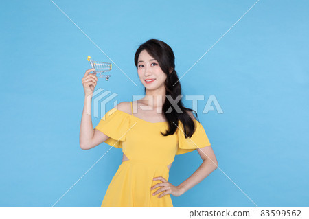 beautiful Korean Asian model with cart miniature, summer shopping event concept beautiful Korean Asian model with cart miniature, summer shopping event concept 83599562