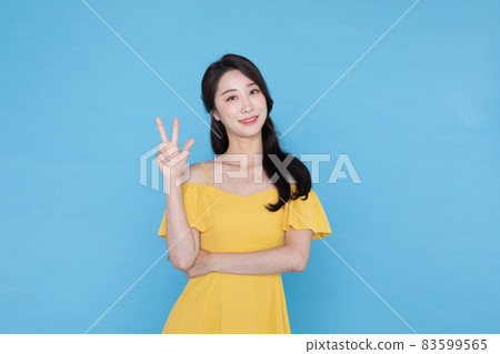 A beautiful Korean Asian woman doing the number three hand gesture A beautiful Korean Asian woman doing the number three hand gesture 83599565