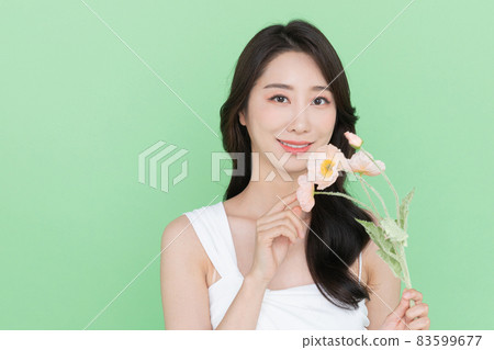 beauty concept, beautiful smiling Korean Asian woman with flower beauty concept, beautiful smiling Korean Asian woman with flower 83599677