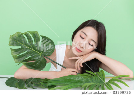 summer beauty concept, beautiful Korean Asian woman holding green leaves summer beauty concept, beautiful Korean Asian woman holding green leaves 83599726