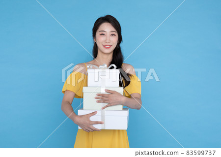 shopping event concept, beautiful Korean Asian woman in yellow summer holding gift boxdelivery box shopping event concept, beautiful Korean Asian woman in yellow summer holding gift boxdelivery box 83599737