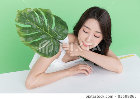 summer beauty concept, beautiful Korean Asian woman holding green leaves summer beauty concept, beautiful Korean Asian woman holding green leaves 83599863