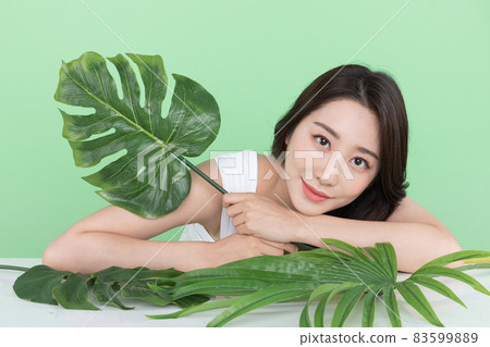 summer beauty concept, beautiful Korean Asian woman holding green leaves summer beauty concept, beautiful Korean Asian woman holding green leaves 83599889