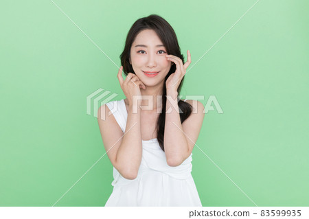 beauty concept, beautiful smiling Korean Asian woman touching eye beauty concept, beautiful smiling Korean Asian woman touching eye 83599935
