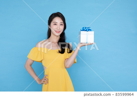 shopping event concept, beautiful Korean Asian woman in yellow summer holding gift boxdelivery box shopping event concept, beautiful Korean Asian woman in yellow summer holding gift boxdelivery box 83599964