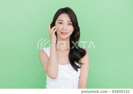 beauty concept, beautiful smiling Korean Asian woman touching eye beauty concept, beautiful smiling Korean Asian woman touching eye 83600182