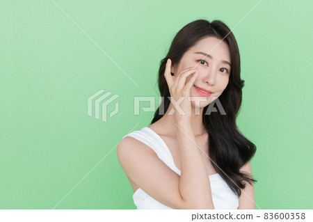 beauty concept, beautiful smiling Korean Asian woman touching eye beauty concept, beautiful smiling Korean Asian woman touching eye 83600358