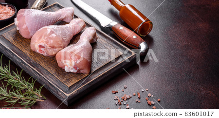Fresh raw chicken legs with spices, salt and herbs on a cutting board Fresh raw chicken legs with spices, salt and herbs on a cutting board 83601017