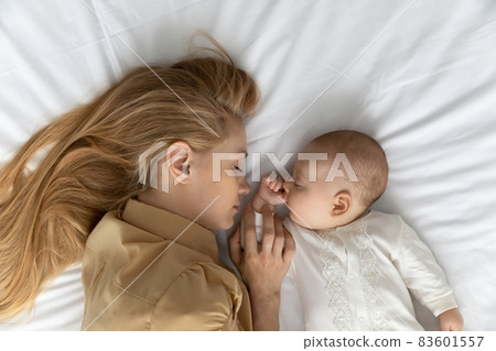 Top view young tired mother and baby sleeping together Top view young tired mother and baby sleeping together 83601557