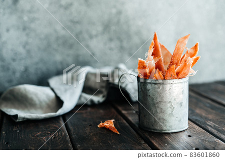 Dried chicken, dried poultry, cut into strips in a metal bucket on a wooden background. Serving a meal in a restaurant 83601860