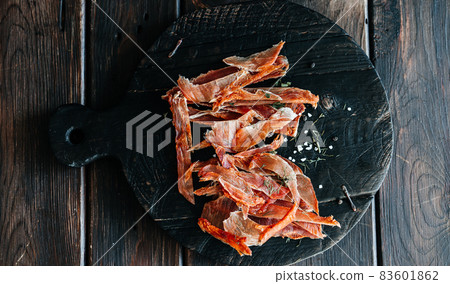 Dried chicken cut into strips on a wooden board with salt and pepper 83601862